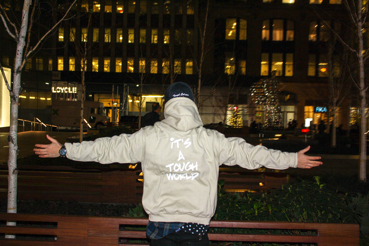 It's A Tough World jacket against city lights at night